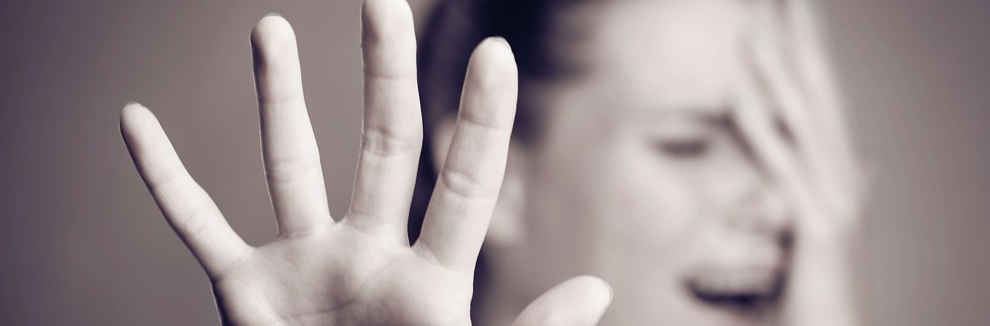 Gewalt und Aggression - Abwehrhaltung Eine Hand wird in Abwehrhaltung gehoben. (Schwarz-weiß-Bild)